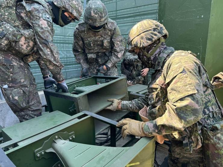 South Korean soldiers inspect loudspeakers before installing them near the inter-Korean border, in this recent photo. The South Korean government decided, Sunday, to resume loudspeaker propaganda broadcasts along the border in response to North Korea's recent launches of trash-carrying balloons. Courtesy of Joint Chiefs of Staff 